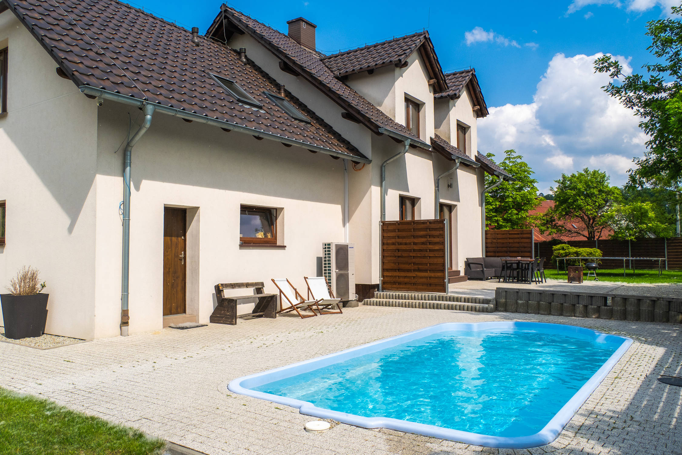 Budynek apartamentów z ogrodowym basenem w słoneczny dzień.