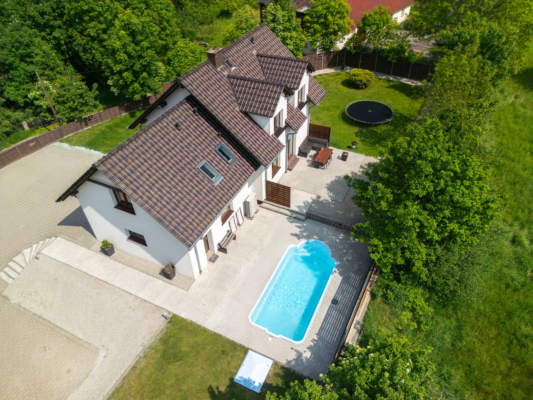 Widok z drona na budynek Apartamentów B2, ogród i odkryty basen.